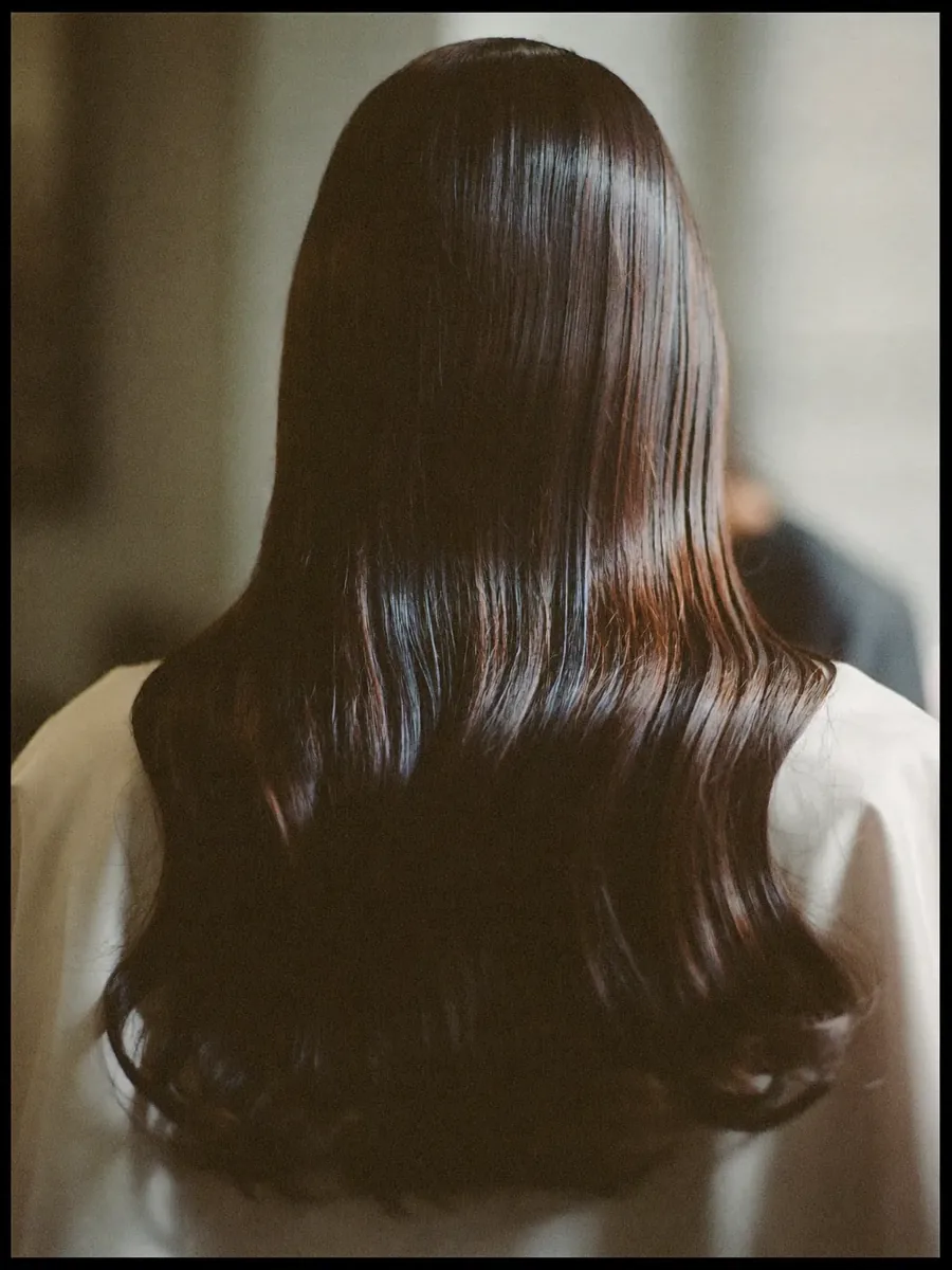Long dark hair finished straight and glossy