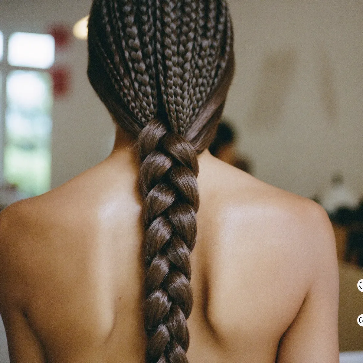 Finished long braids gathered over one shoulder