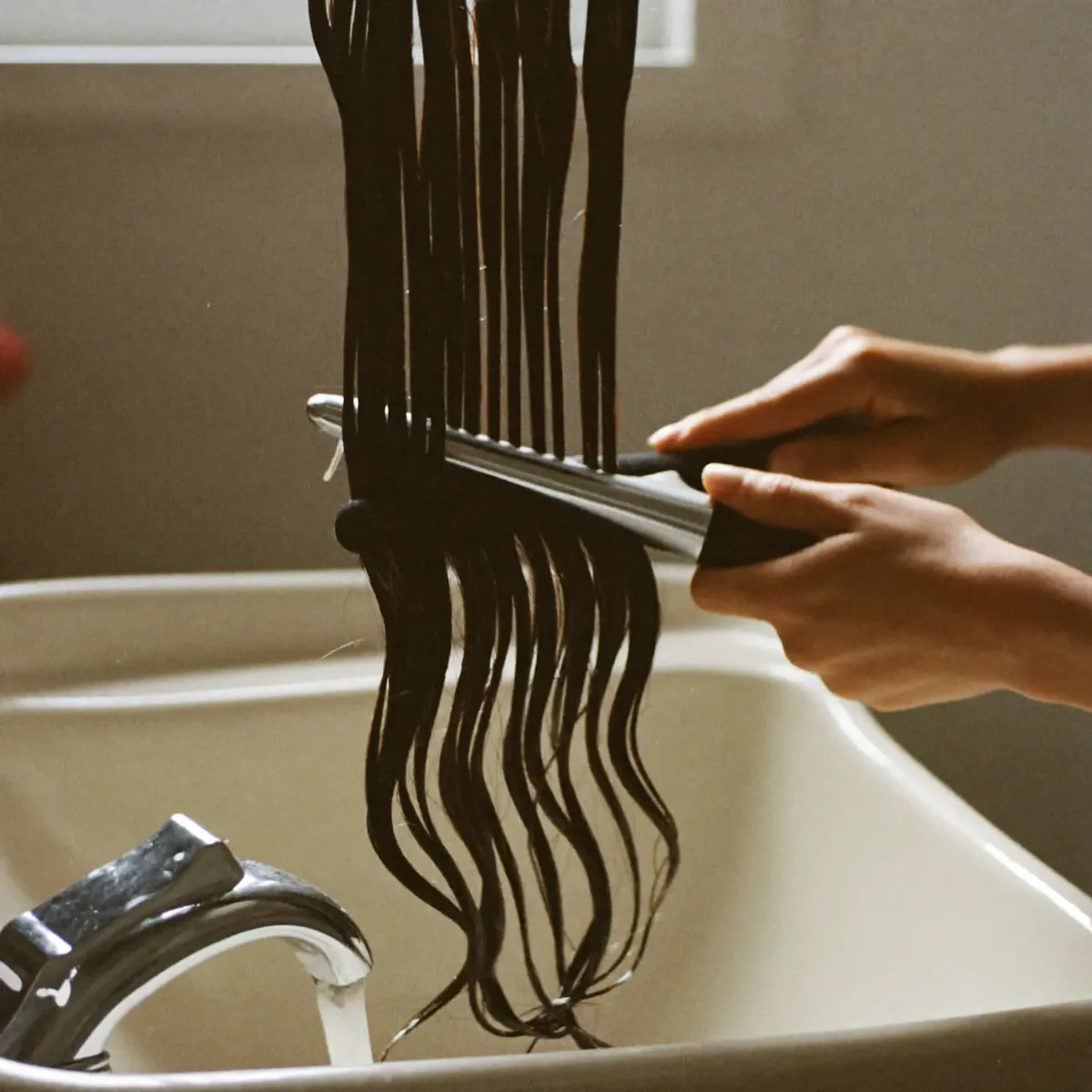 Wet hair being combed through after a wash