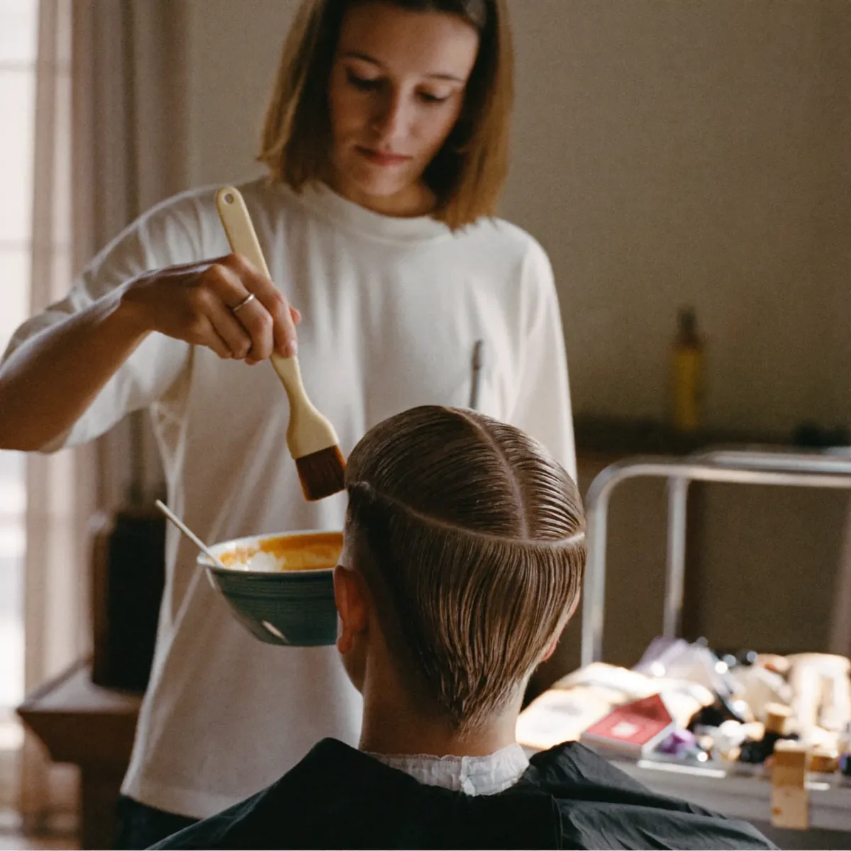 Colour being applied to sectioned hair at the salon chair